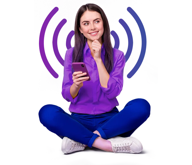 A woman sitting on the floor, using a cell phone.