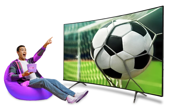 A man sitting in a bean bag chair, engrossed in a soccer ball displayed on the screen.