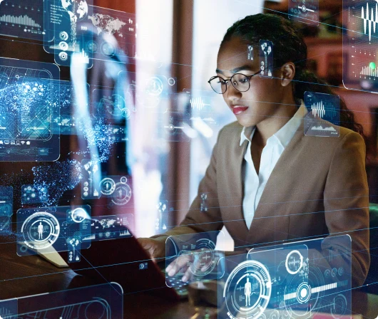 A professional woman in a suit working on a laptop with a digital interface