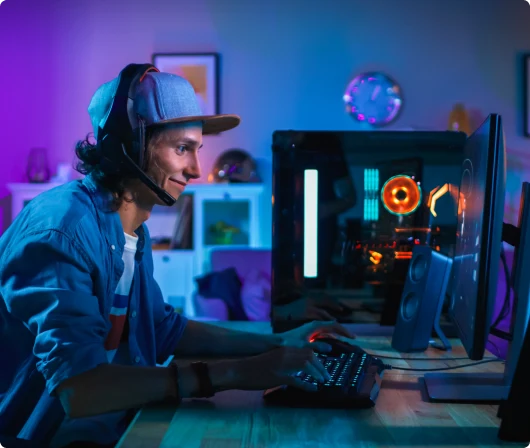 A man wearing headphones and a hat engrossed in playing a video game.